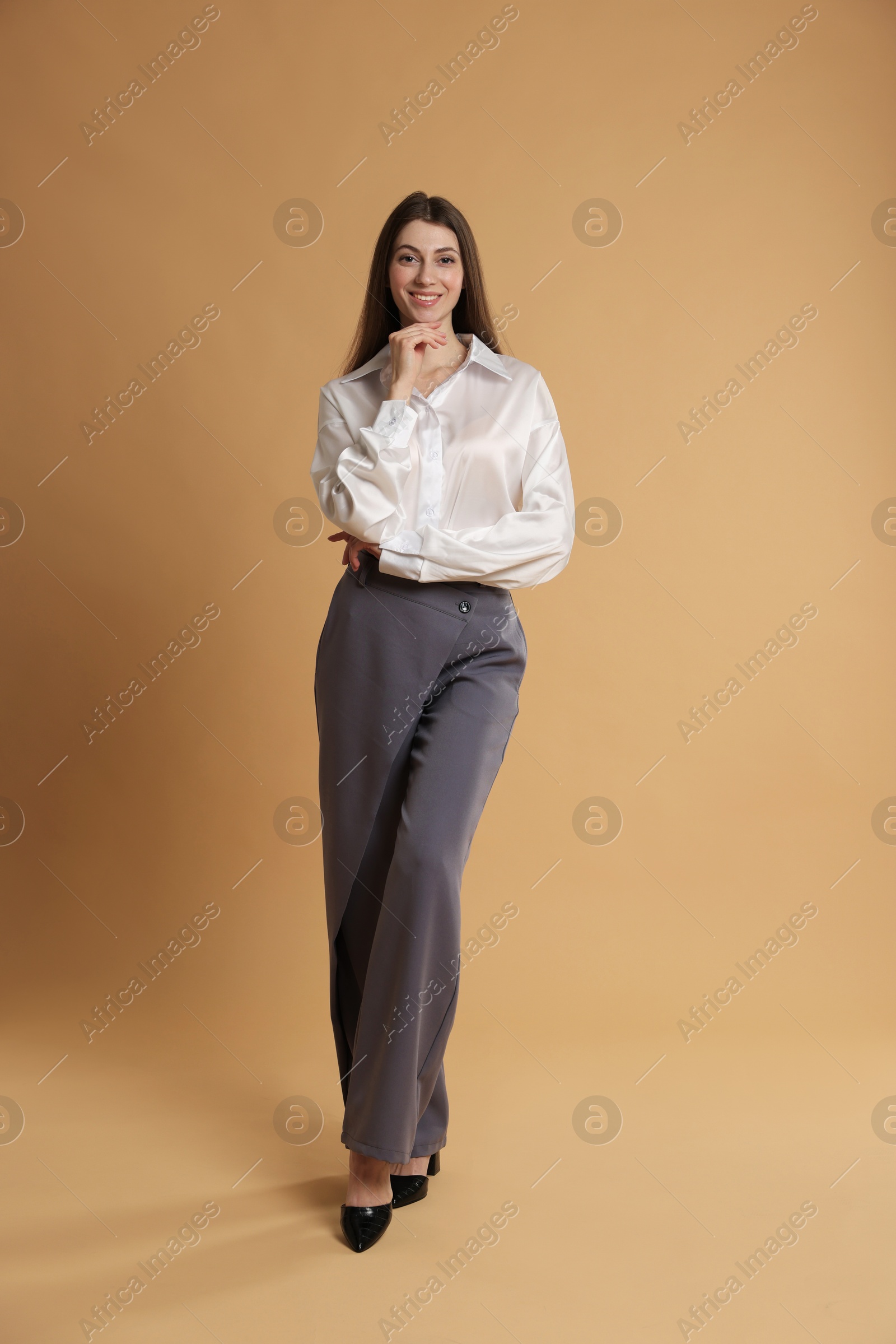 Photo of Beautiful woman in stylish outfit on beige background