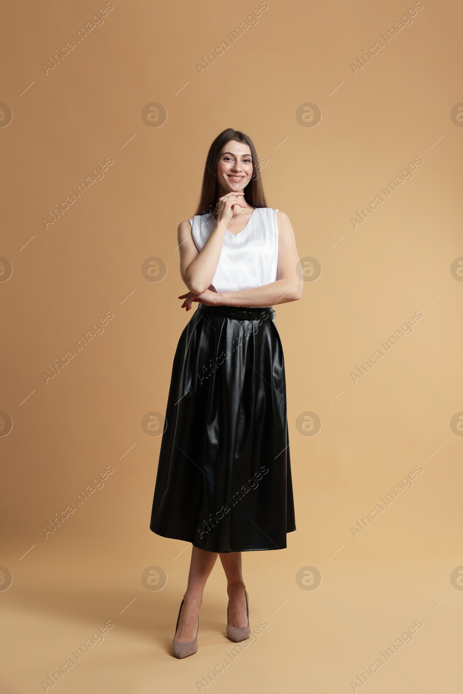 Photo of Beautiful woman in stylish outfit on beige background