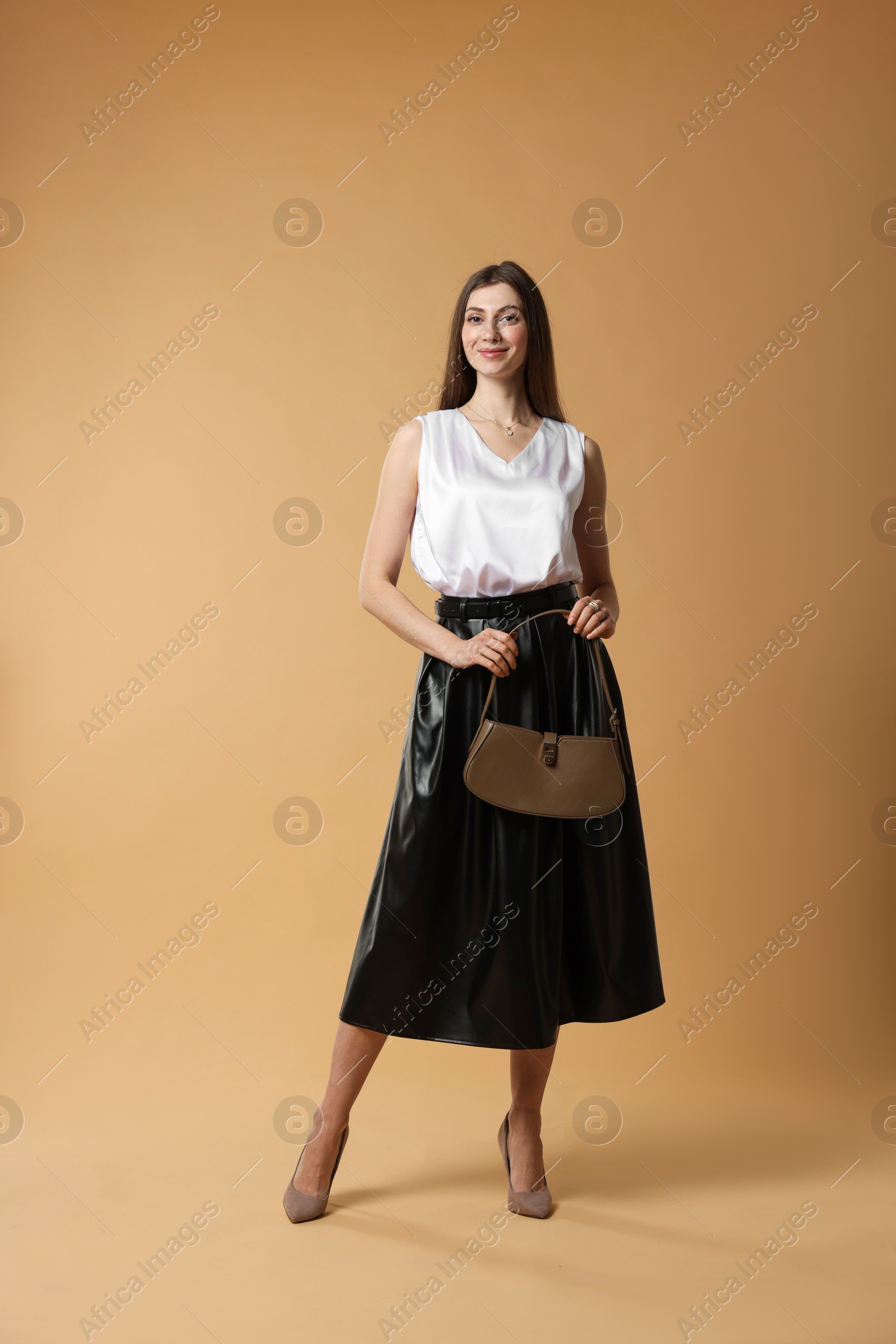 Photo of Beautiful woman in stylish outfit on beige background