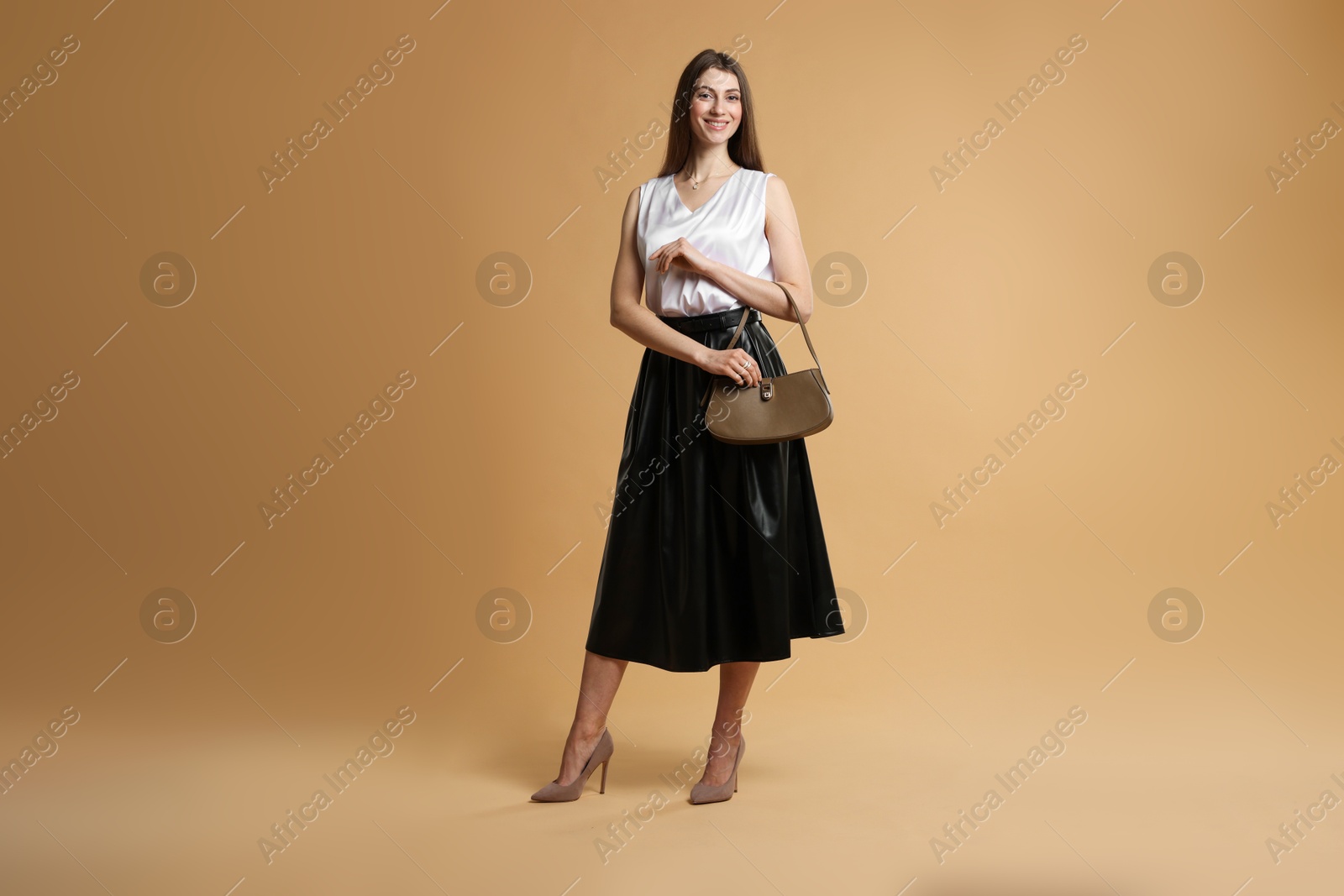 Photo of Beautiful woman in stylish outfit on beige background