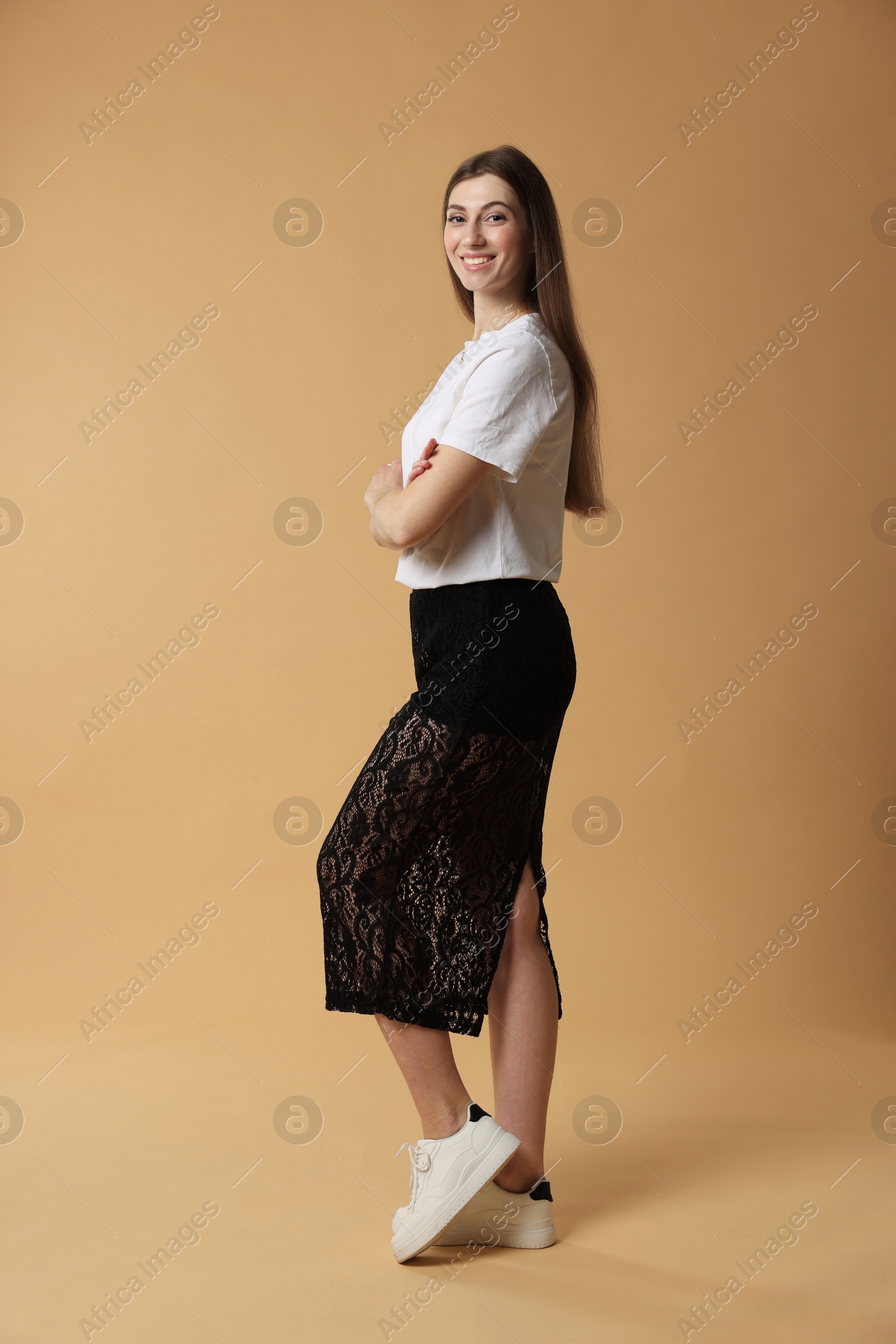 Photo of Beautiful woman in stylish outfit on beige background