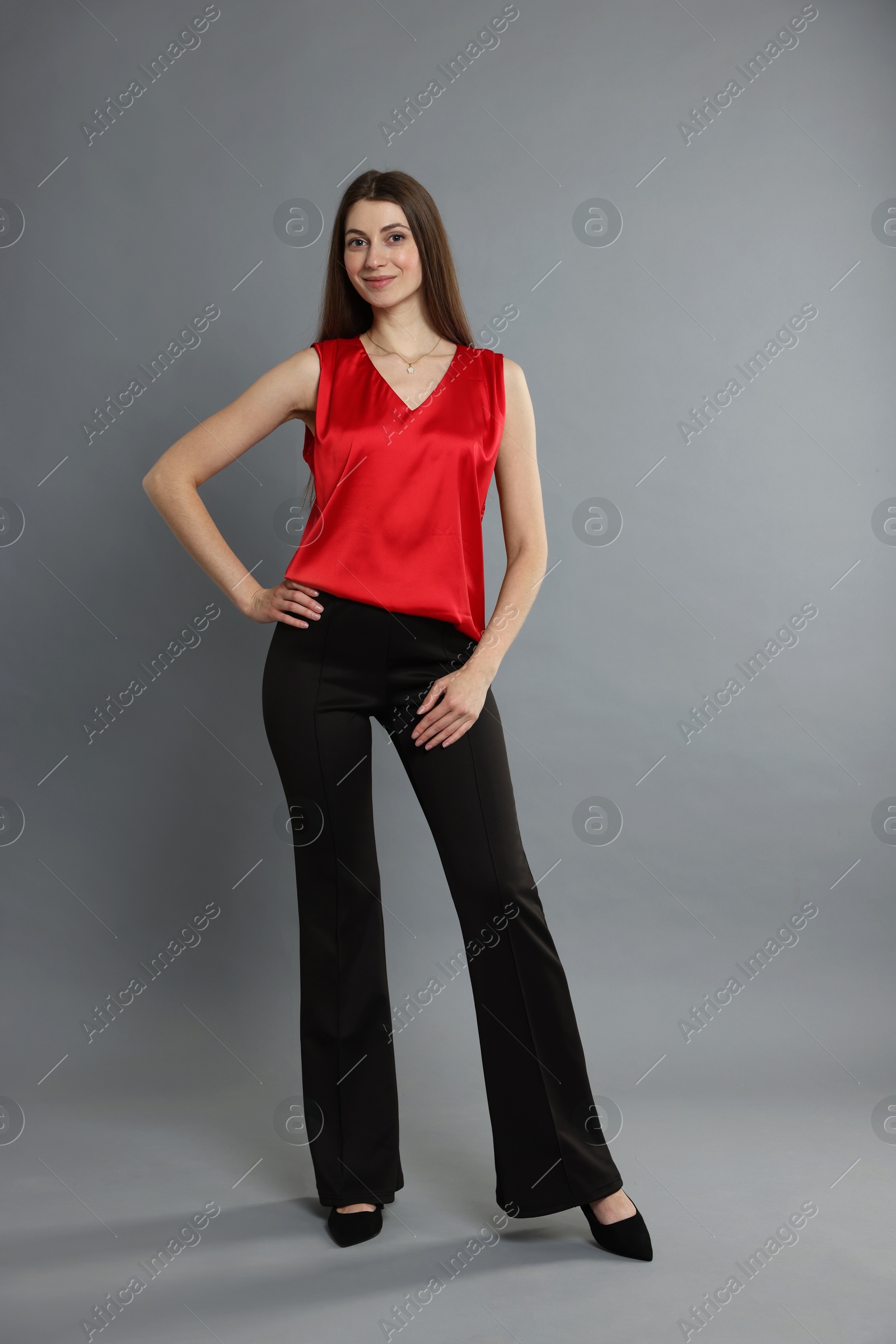 Photo of Beautiful woman in stylish outfit on grey background