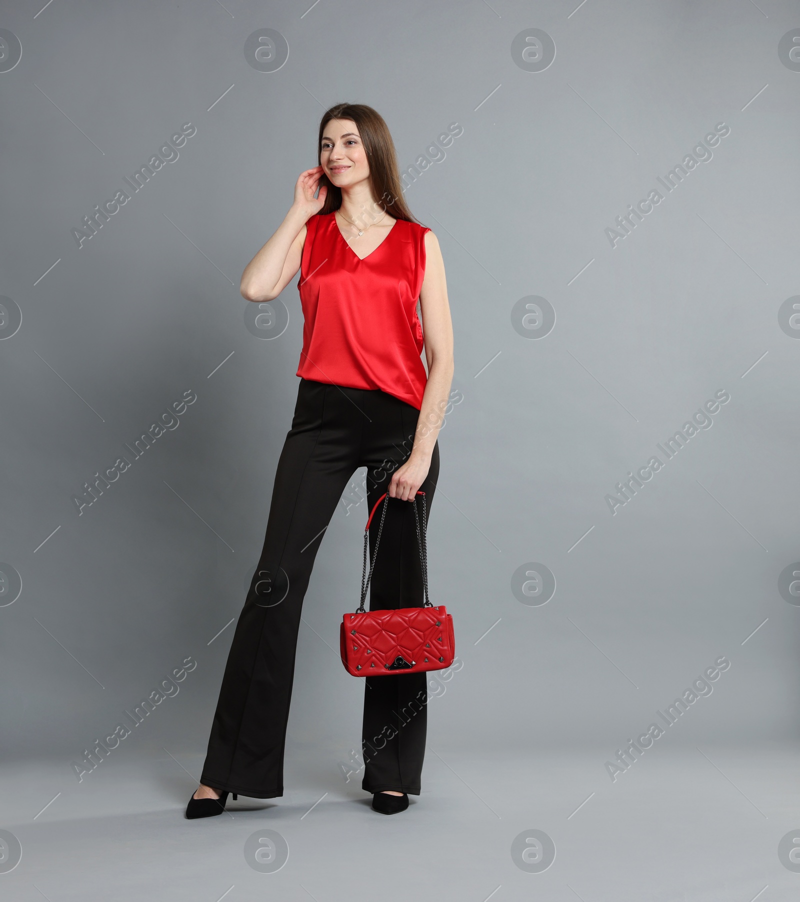 Photo of Beautiful woman in stylish outfit on grey background