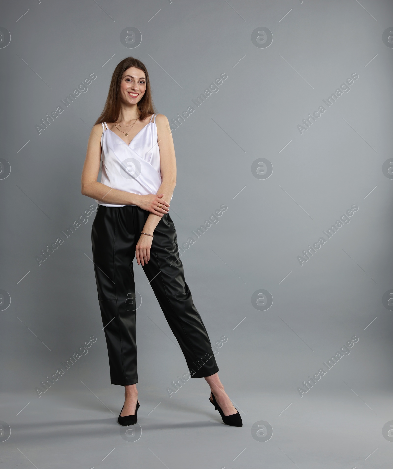 Photo of Beautiful woman in stylish outfit on grey background