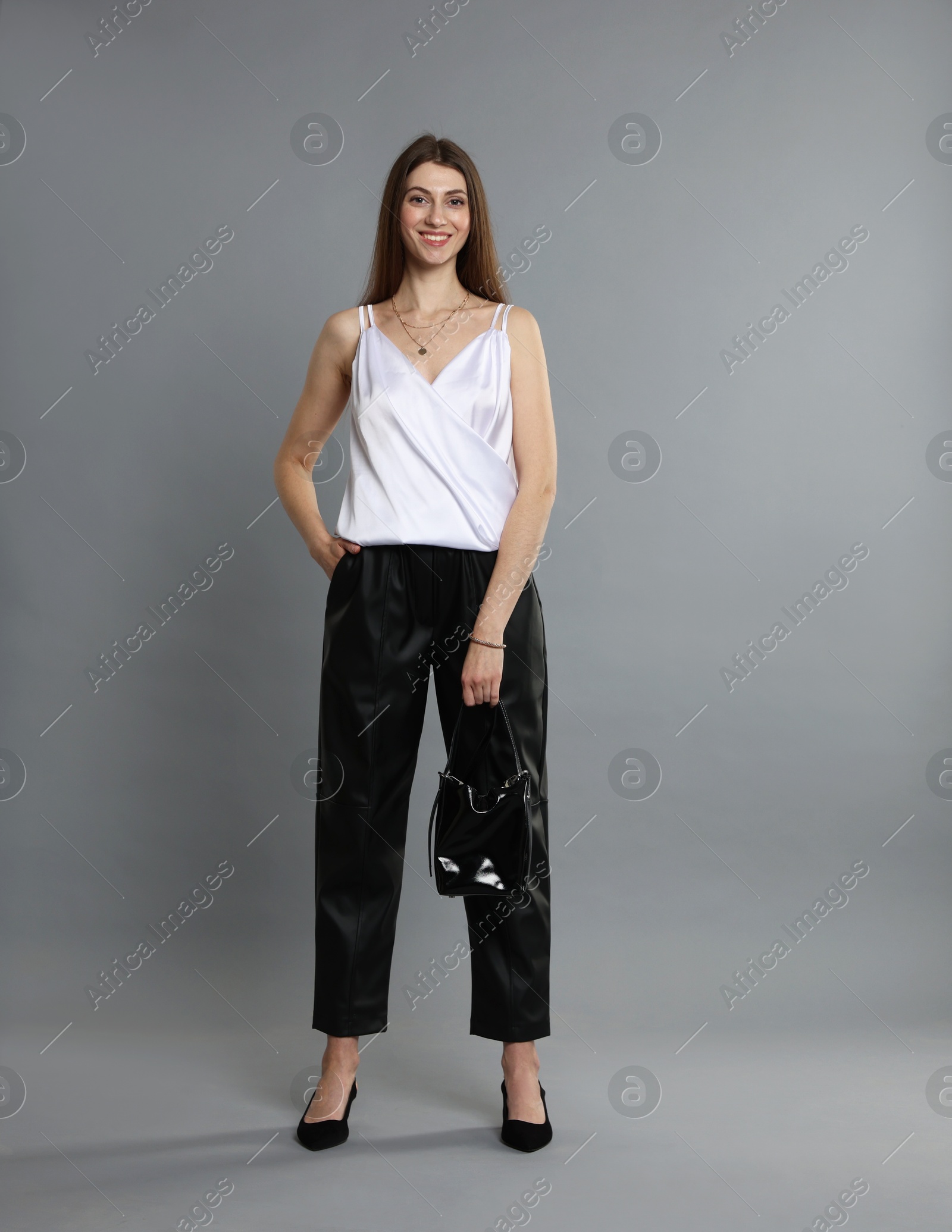 Photo of Beautiful woman in stylish outfit on grey background