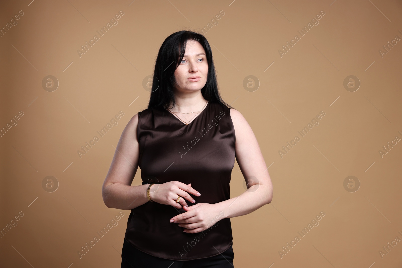 Photo of Portrait of charming plus size model on beige background. Overweight