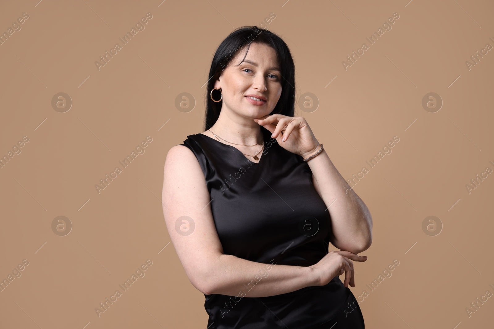 Photo of Portrait of smiling plus size model on beige background. Overweight