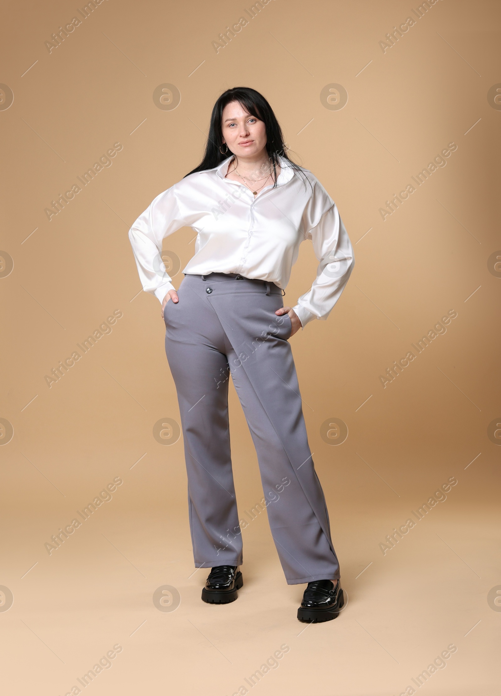 Photo of Charming plus size model on beige background. Overweight