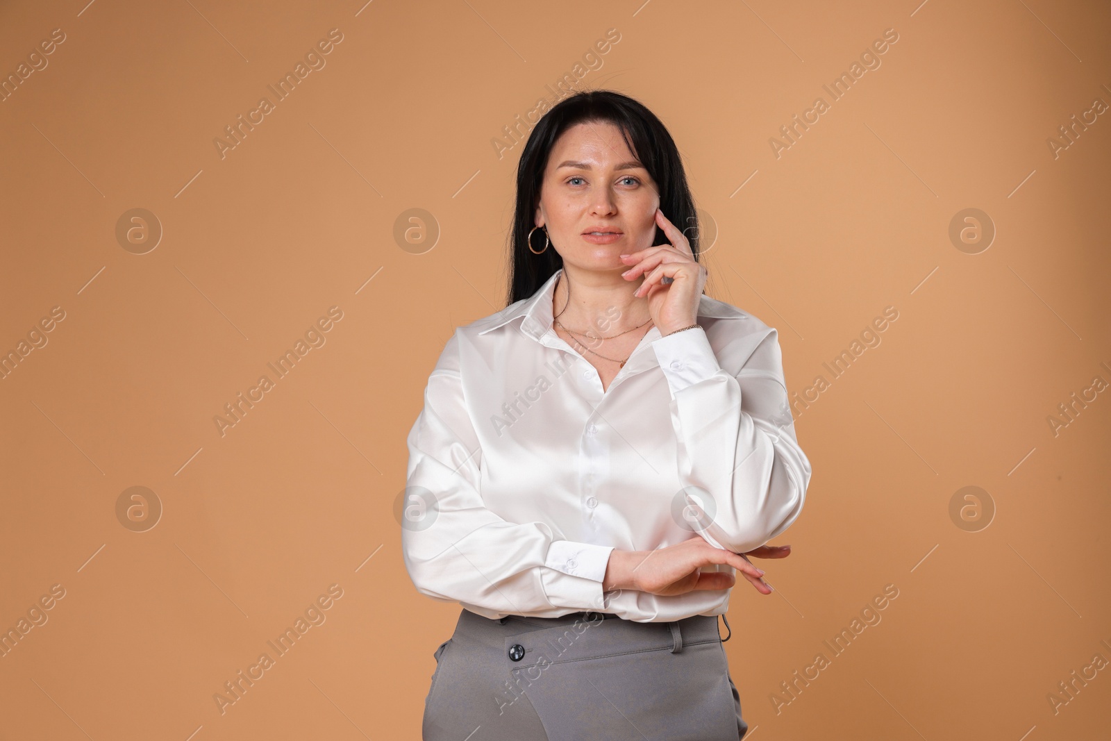 Photo of Portrait of charming plus size model on beige background. Overweight