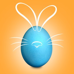 Image of Blue Easter egg with bunny ears, nose and whiskers on orange background