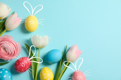 Image of Bright Easter eggs and flowers on light blue background, top view. Some of them with bunny ears, noses and whiskers