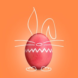 Image of Red Easter egg with bunny ears, nose, paws and whiskers on orange background