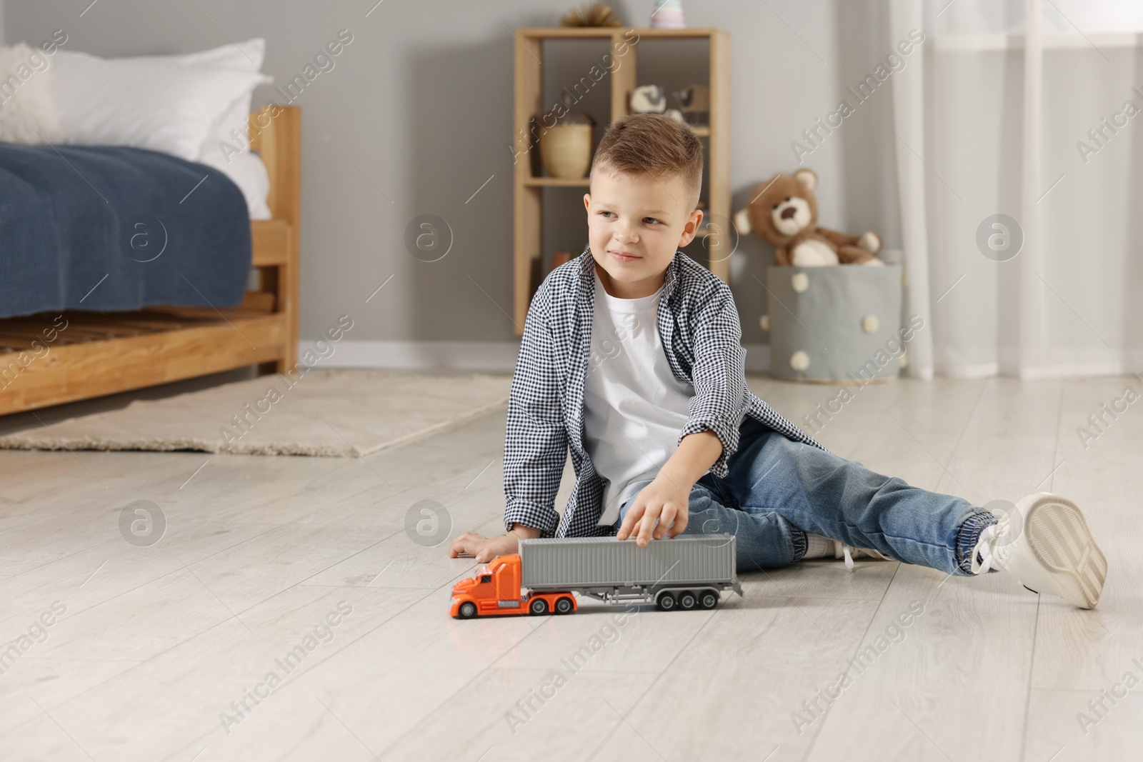 Photo of Little boy playing with toy car at home