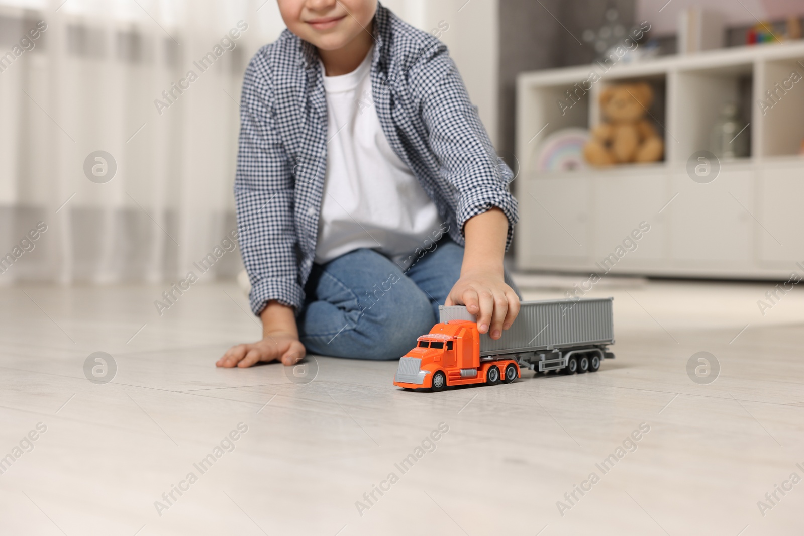 Photo of Little boy playing with toy car at home, closeup