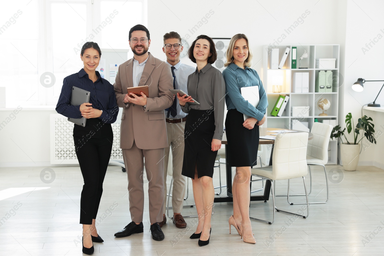 Photo of Portrait of happy coworkers in formal clothes indoors