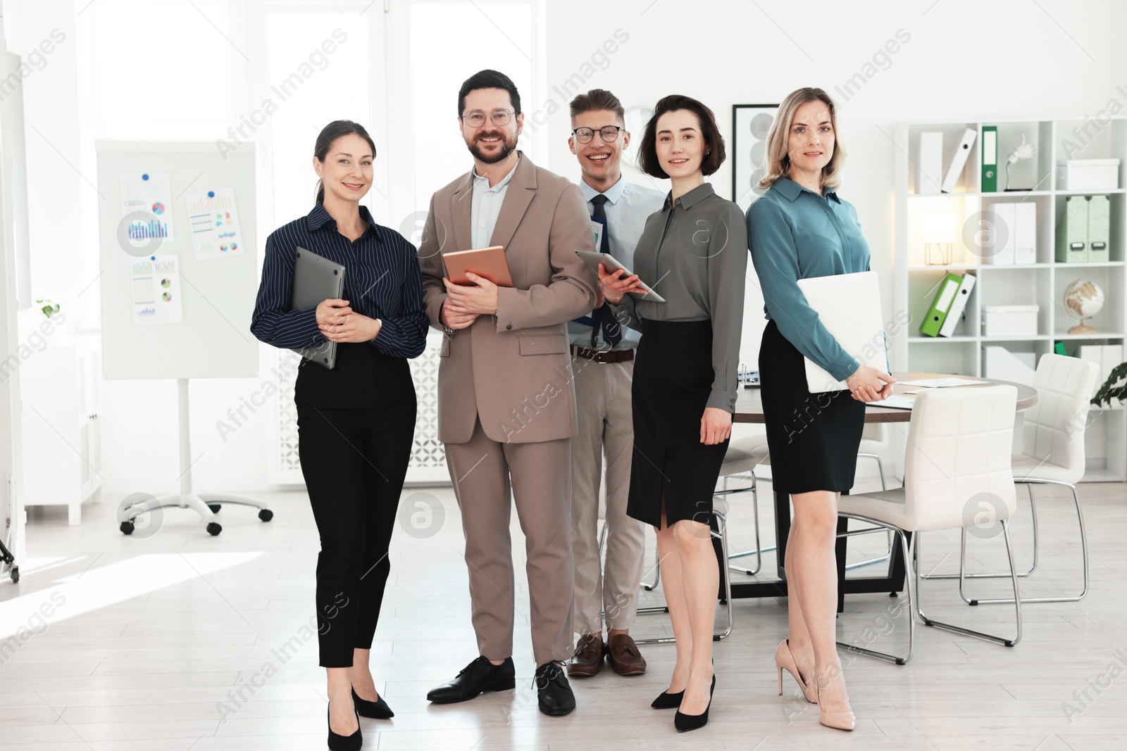 Photo of Portrait of happy coworkers in formal clothes indoors