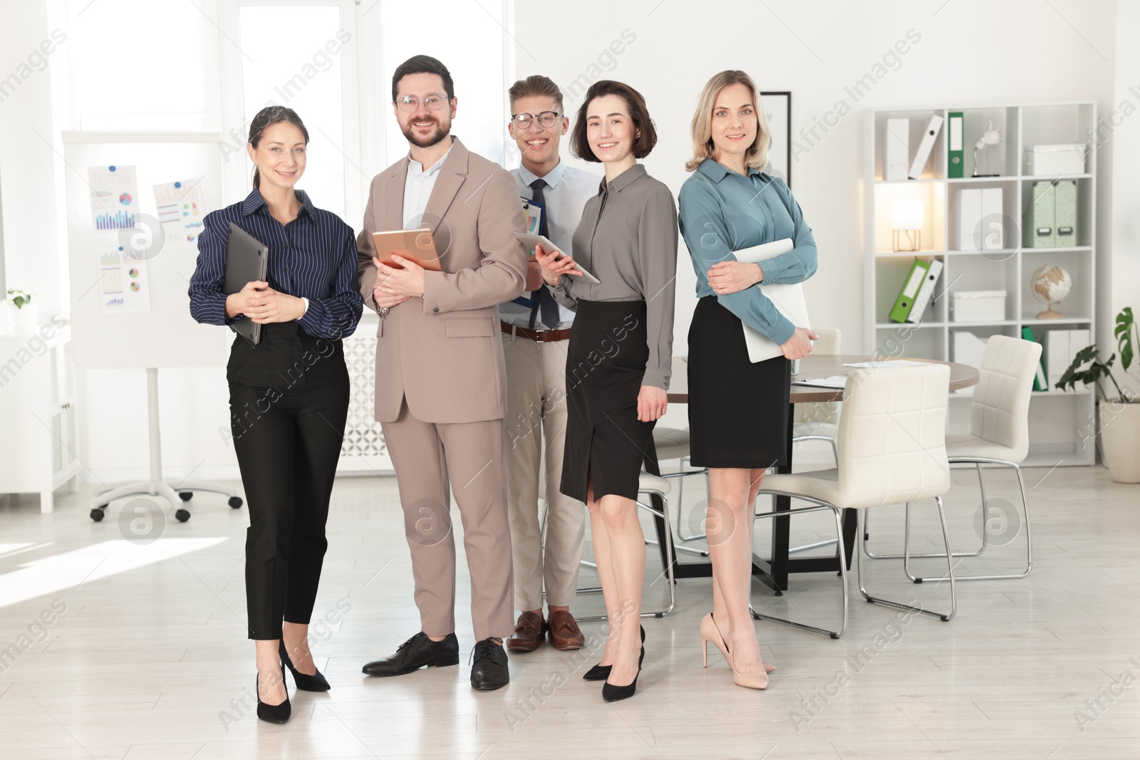 Photo of Portrait of happy coworkers in formal clothes indoors