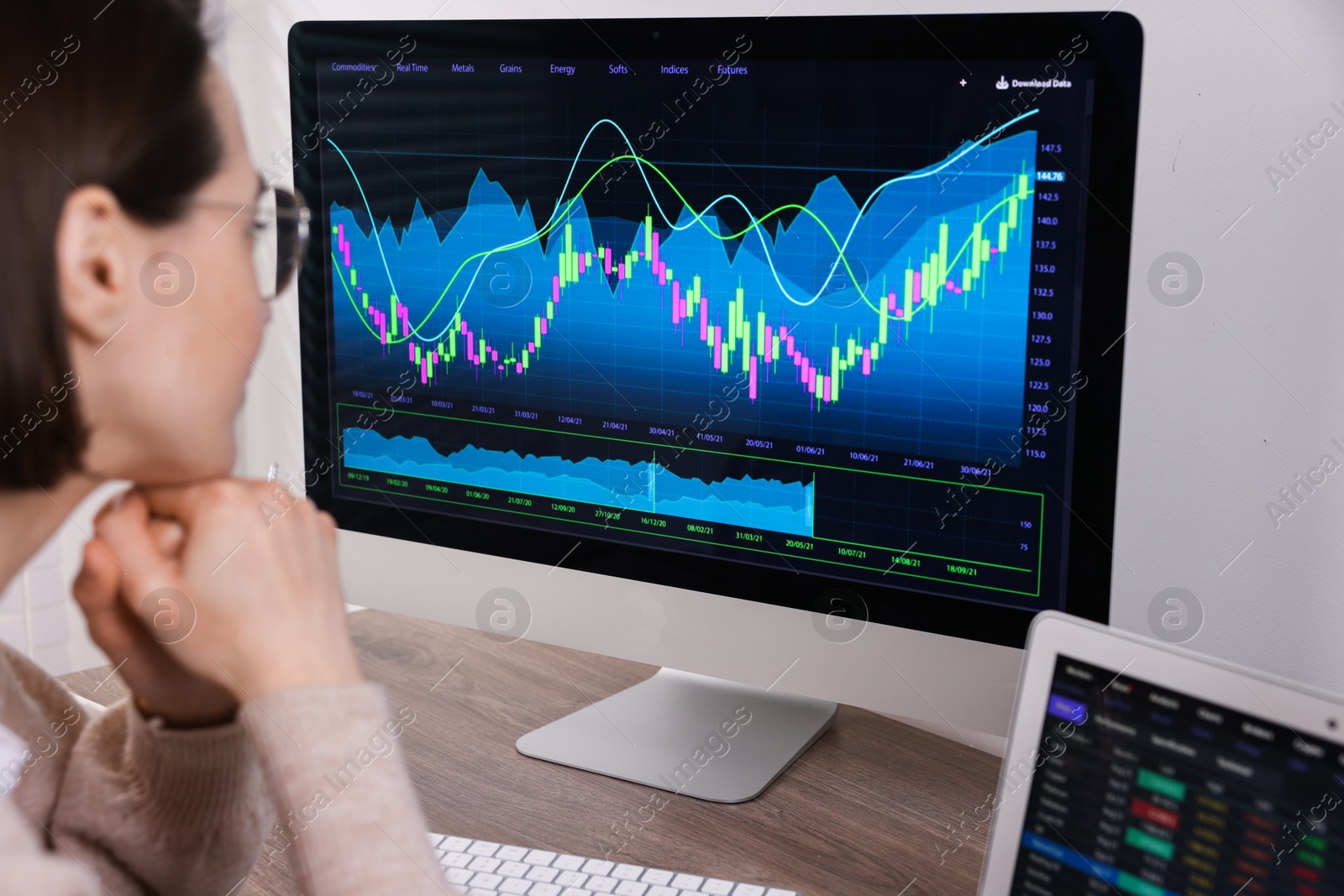 Photo of Stock exchange. Woman analysing financial market on computer at wooden table indoors