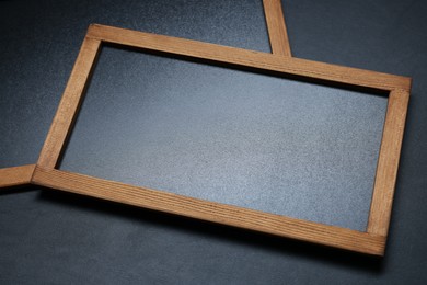 Photo of Blank small blackboards on black textured background, above view