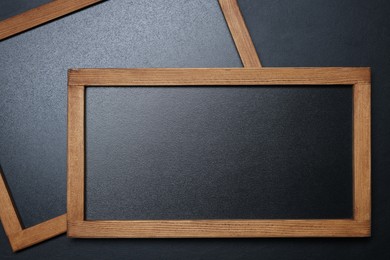 Photo of Blank small blackboards on black textured background, top view