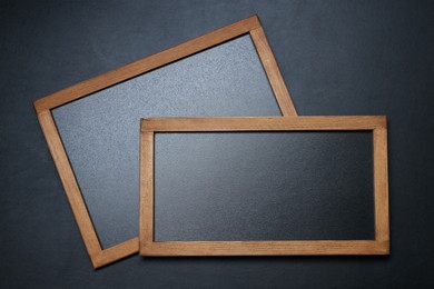 Photo of Blank small blackboards on black textured background, top view