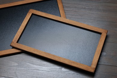 Photo of Blank small blackboards on wooden background, closeup