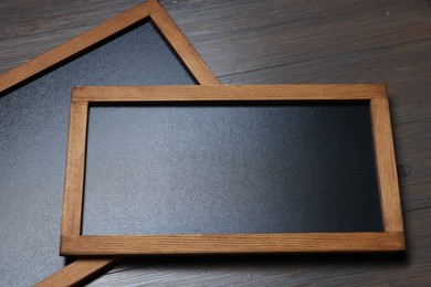 Photo of Blank small blackboards on wooden background, closeup