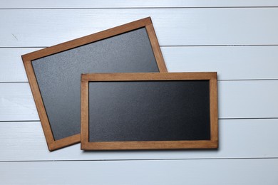 Photo of Blank small blackboards on white wooden background, top view