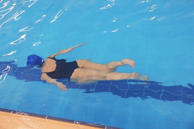 Photo of Woman swimming under water in indoor pool