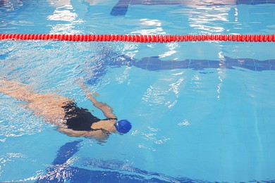 Photo of Woman swimming under water in indoor pool