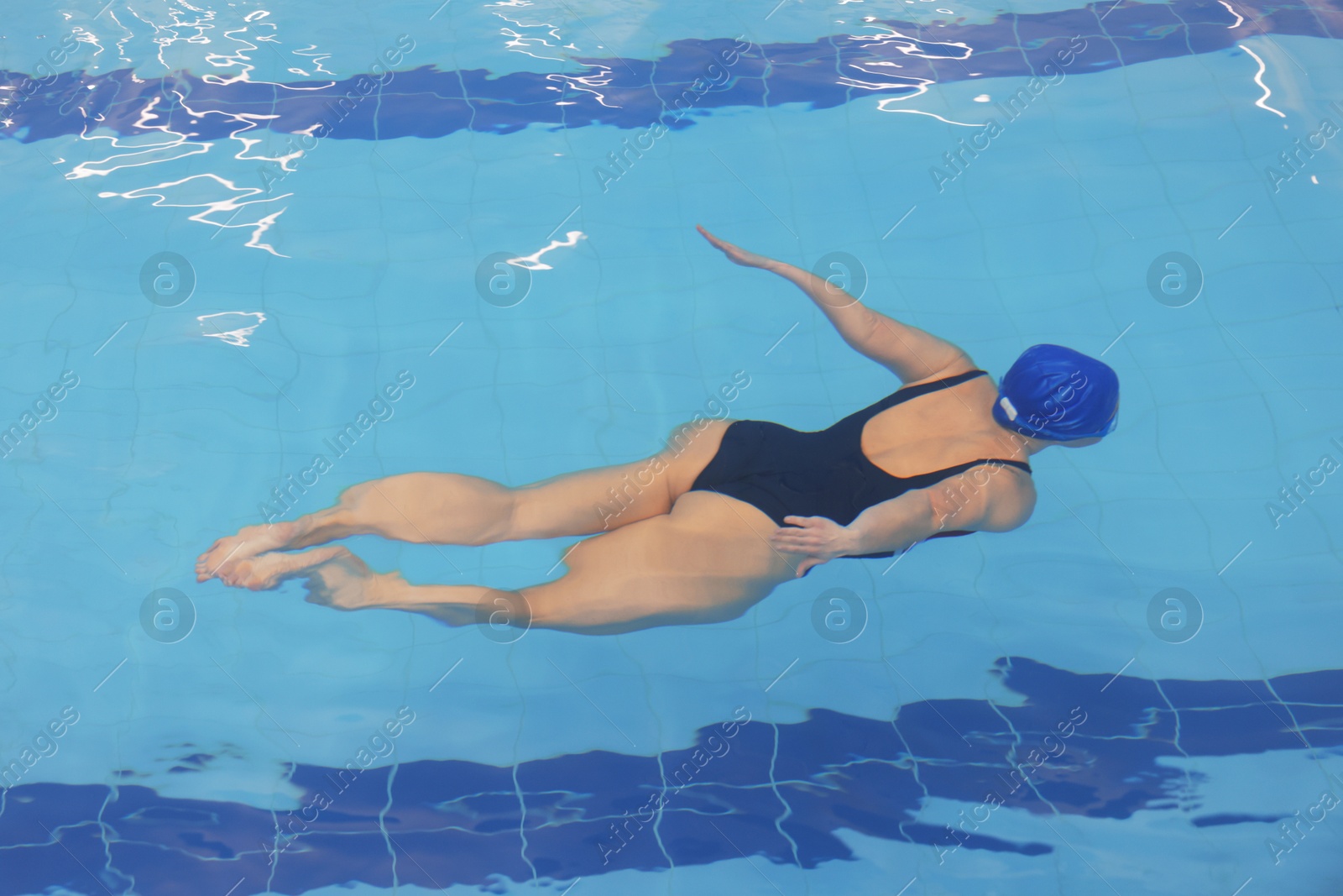 Photo of Woman swimming under water in indoor pool