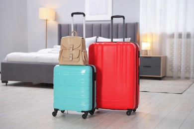 Stylish suitcases with backpack in hotel room