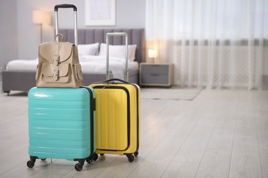 Photo of Stylish suitcases with backpack in hotel room. Space for text