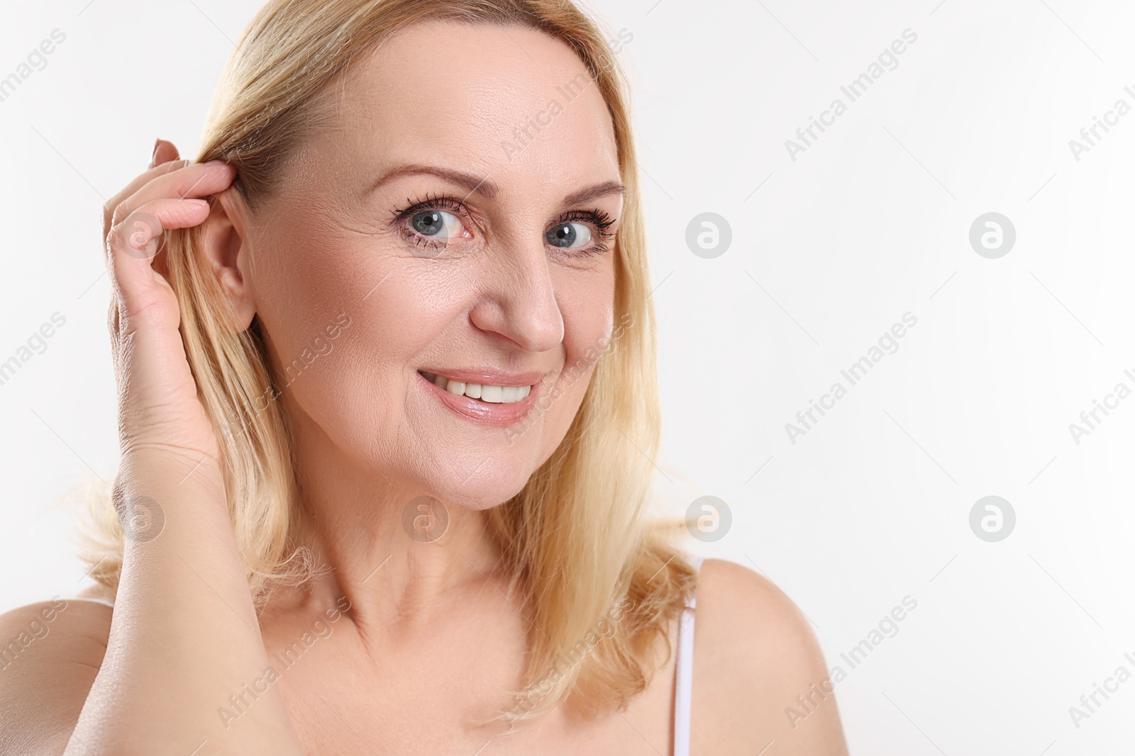 Photo of Portrait of smiling middle aged woman on white background. Space for text