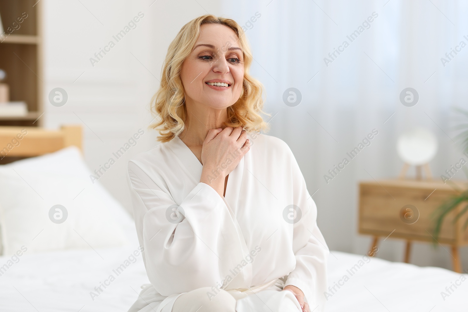 Photo of Smiling middle aged woman posing at home