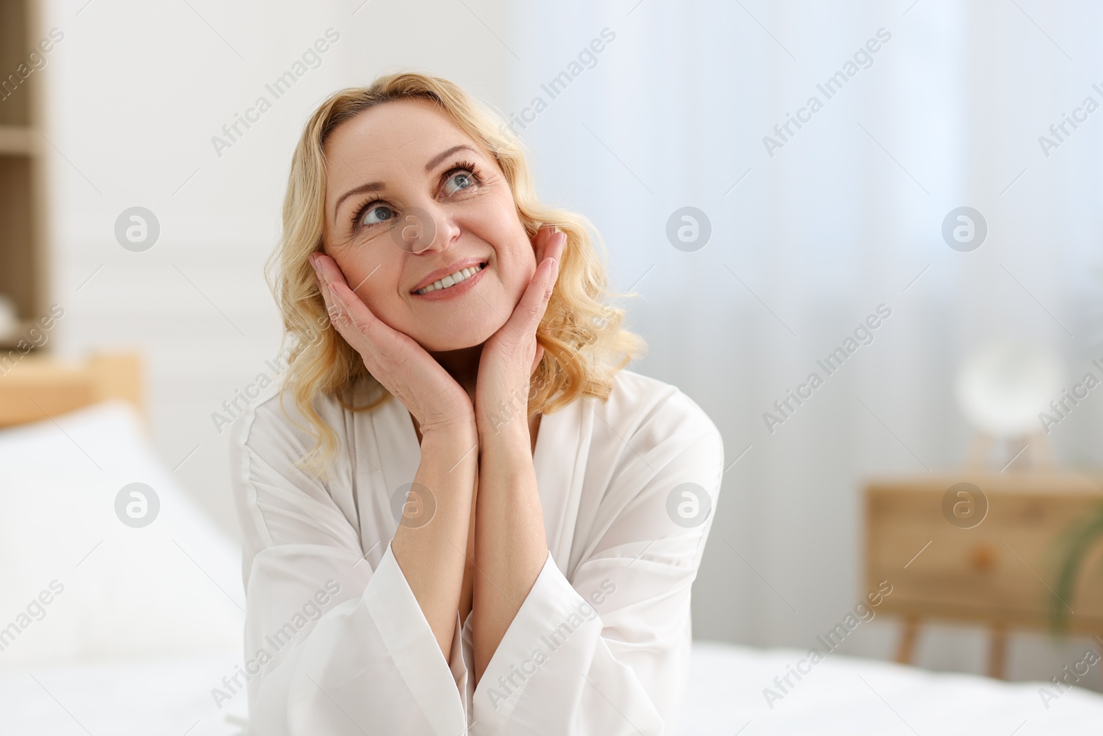 Photo of Smiling middle aged woman at home. Space for text