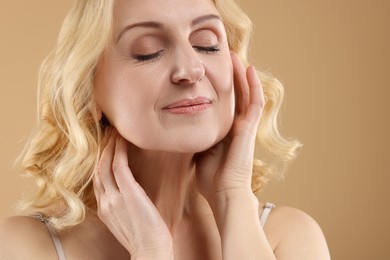 Beautiful middle aged woman on beige background