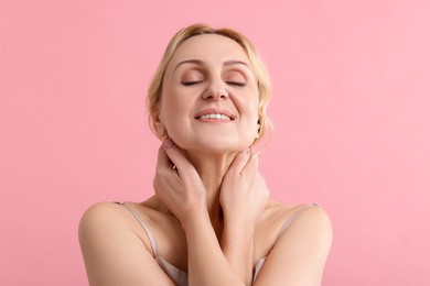 Photo of Smiling middle aged woman on pink background