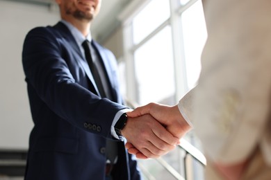 Photo of Men shaking hands in agreement indoors, closeup