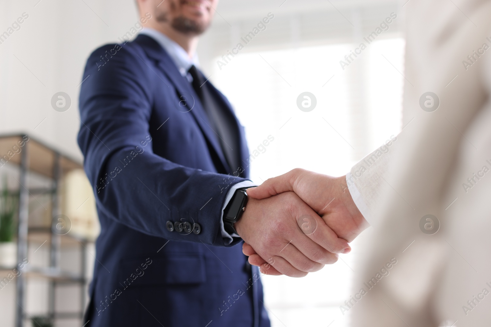 Photo of Men shaking hands during meeting indoors, closeup