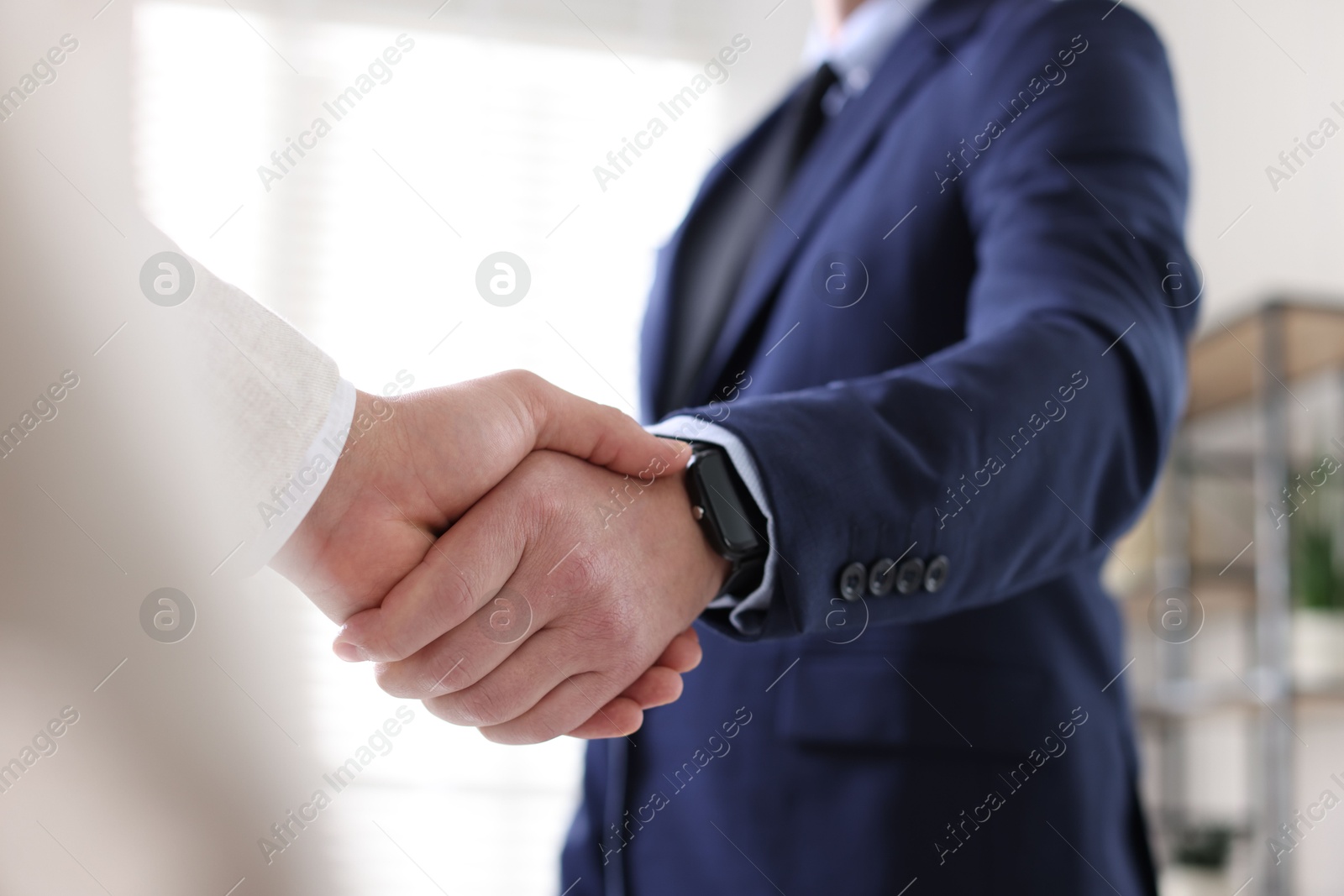 Photo of Men shaking hands during meeting indoors, closeup