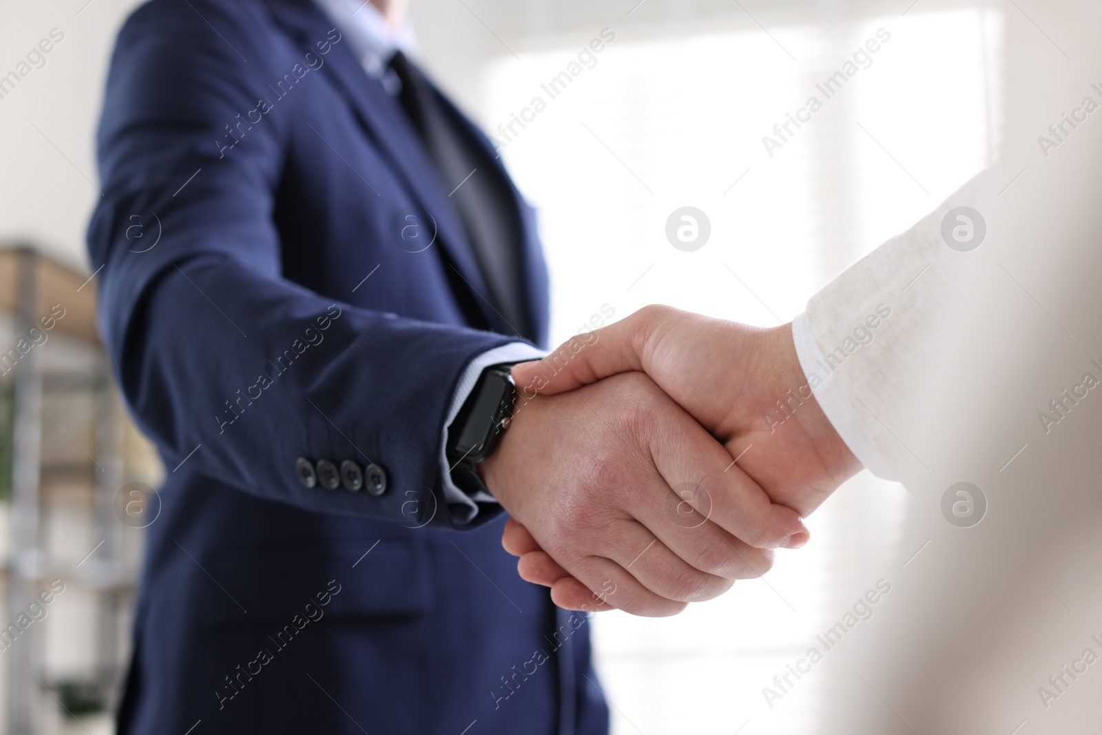 Photo of Men shaking hands during meeting indoors, closeup