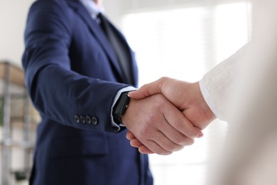 Photo of Men shaking hands during meeting indoors, closeup