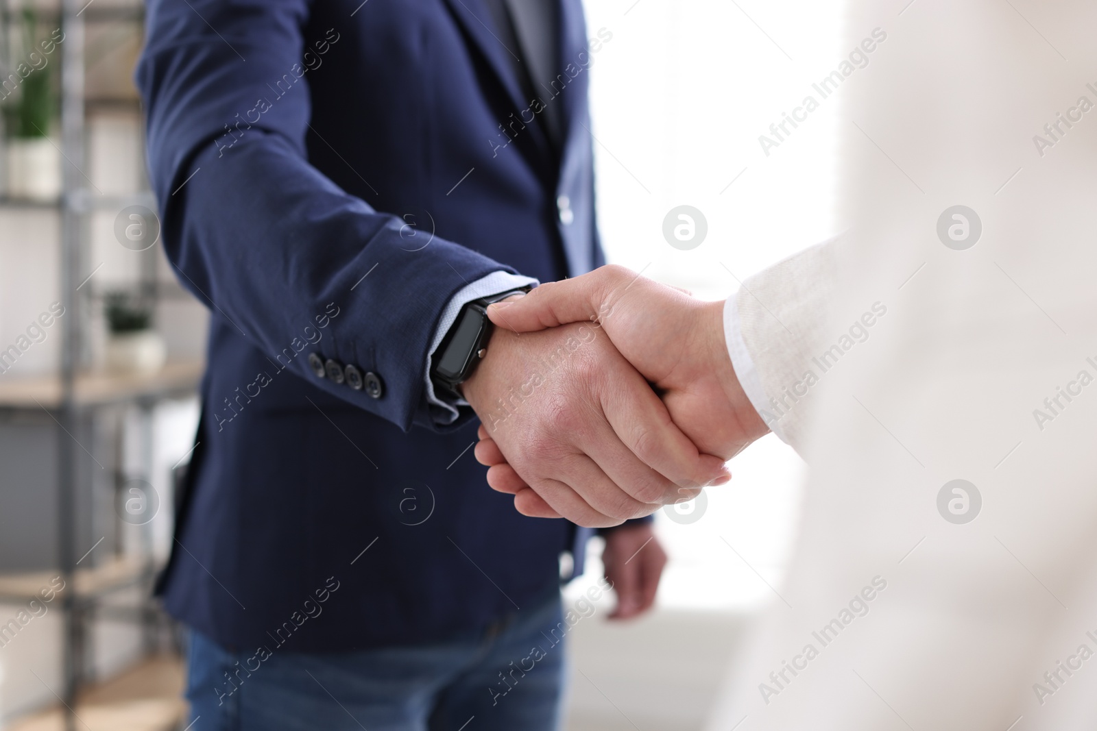 Photo of Men shaking hands during meeting indoors, closeup