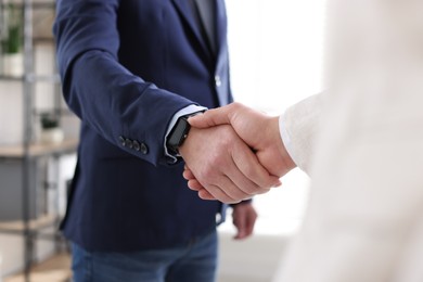 Photo of Men shaking hands during meeting indoors, closeup