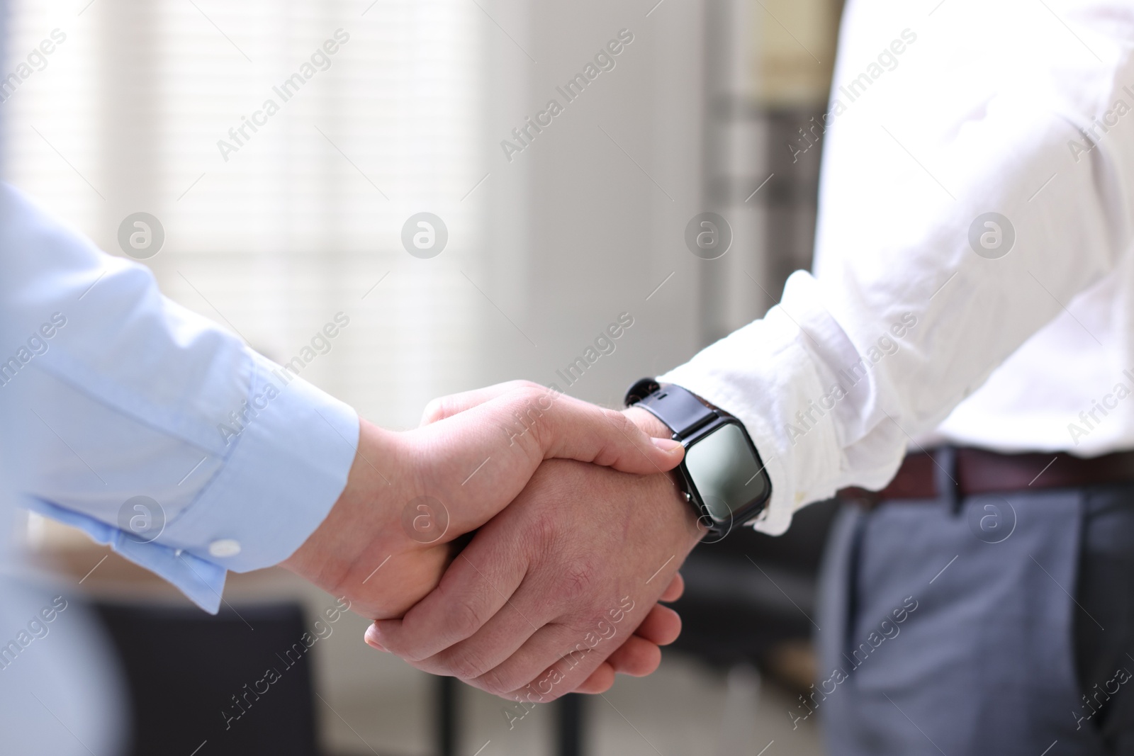 Photo of Men shaking hands in agreement indoors, closeup