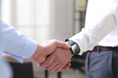 Photo of Men shaking hands in agreement indoors, closeup