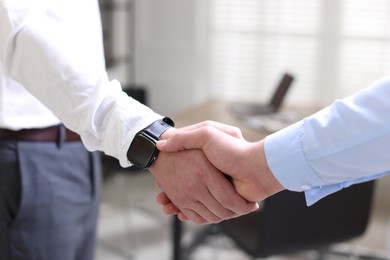 Photo of Men shaking hands in agreement indoors, closeup