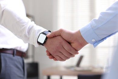 Photo of Men shaking hands in agreement indoors, closeup