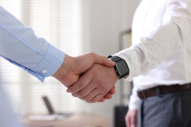 Photo of Men shaking hands in agreement indoors, closeup